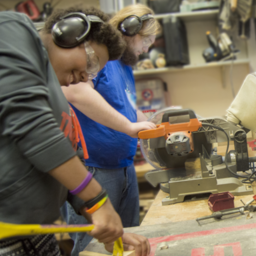 Two CSHers utilizing tools in our Project Room wood shop